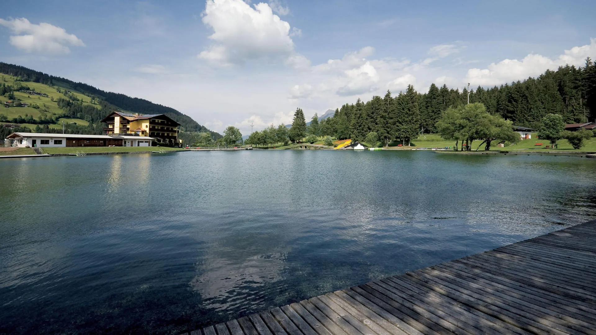 Blick auf den Badesee Kirchberg und die umliegende Landschaft.