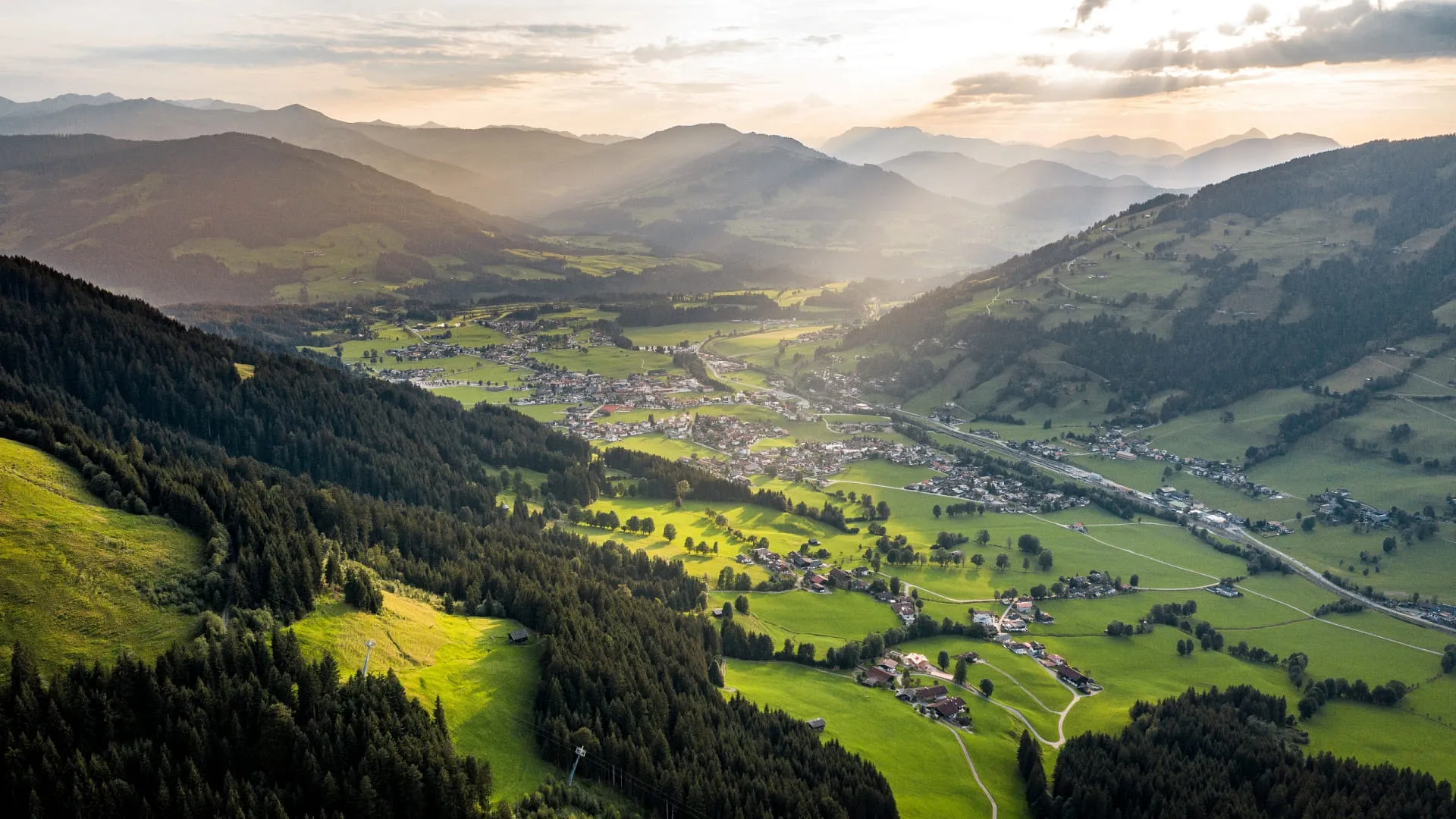 Blick auf das Brixen im Thale Tal mit Bergen und Wiesen